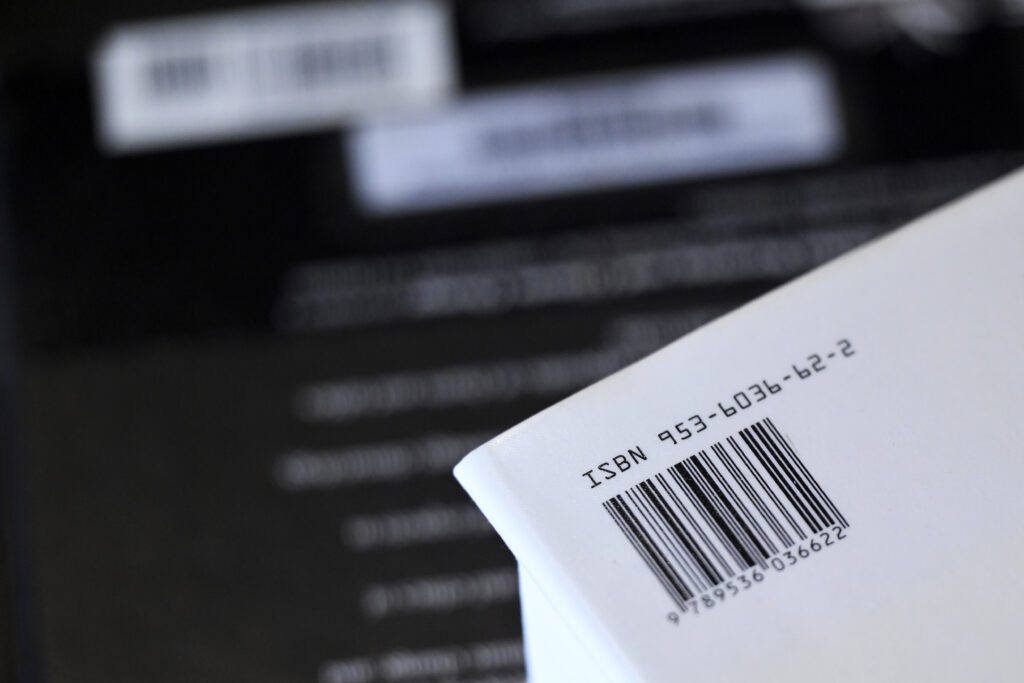 A form with the ISBN and an accompanying barcode in its upper left-hand corner held against a blurred background.