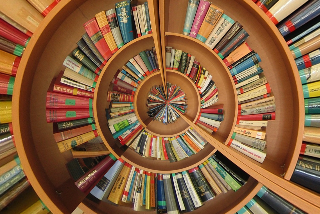 Books on a spiraling bookcase seen from above.