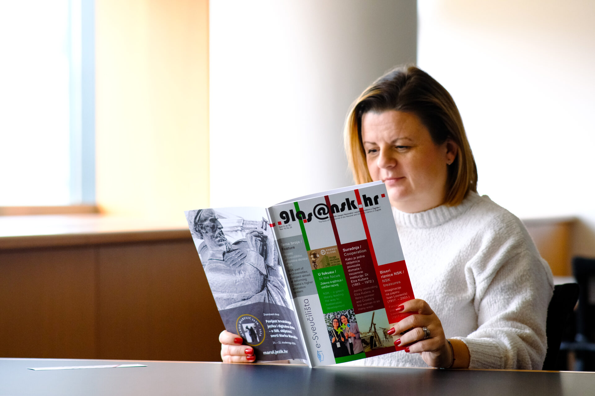 Čitateljica čita novi broj časopisa Glas NSK.