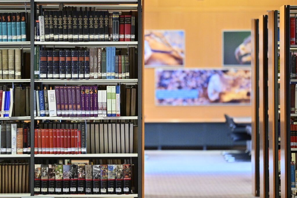 Books on bookshelves in a library reading room.