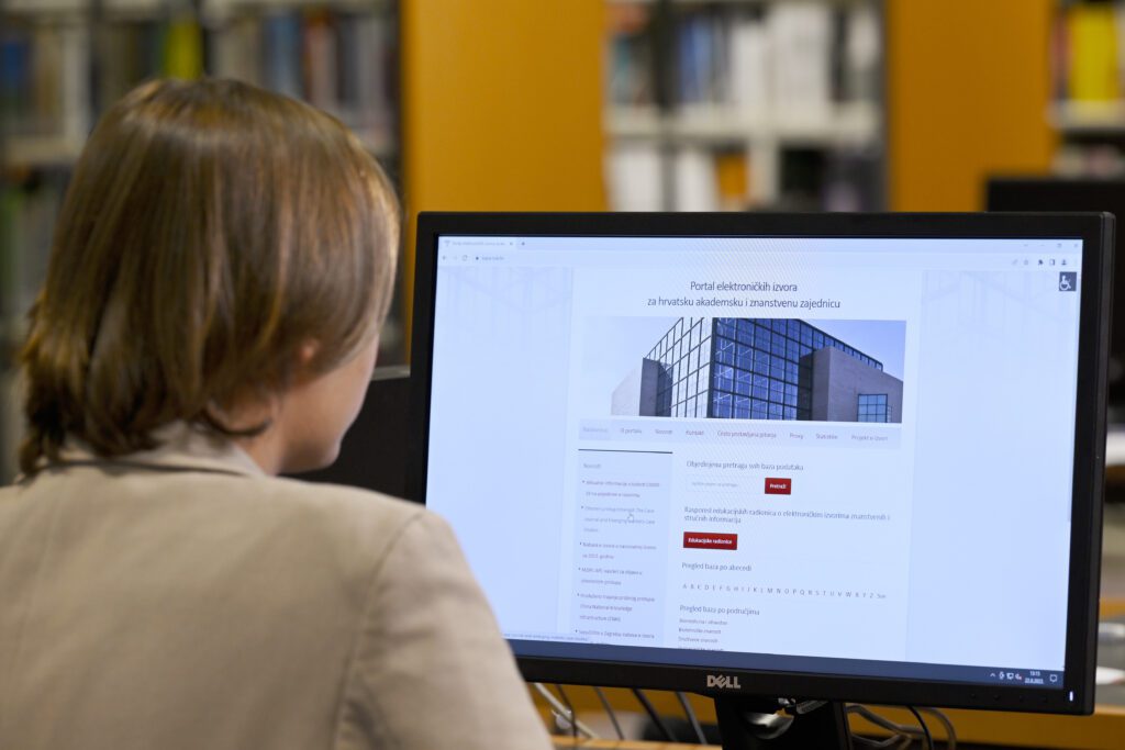 NSK user sitting at a laptop computer whose screen is showing the homepage of the NSK’s e-resources website.