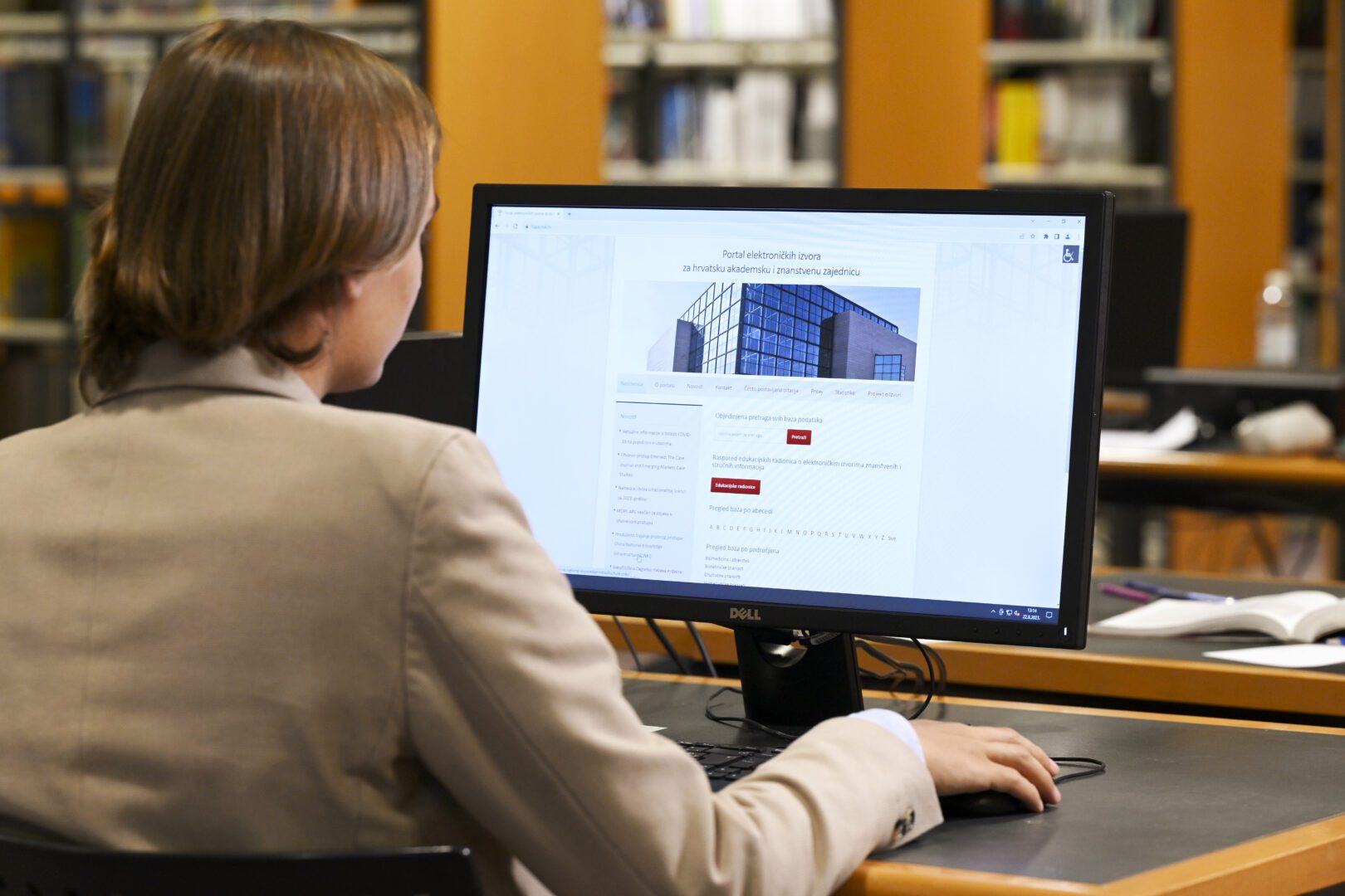NSK user sitting at a laptop computer whose screen is showing the homepage of the NSK’s e-resources website.