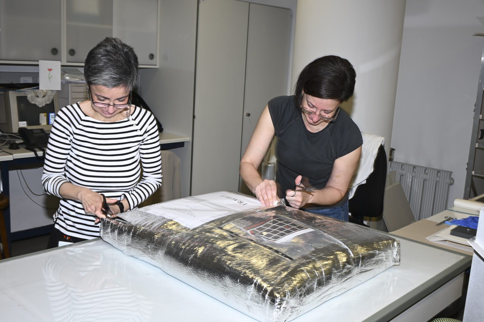 NSK staff unpacking valuable material donated to NSK by Ms Marija Orač.