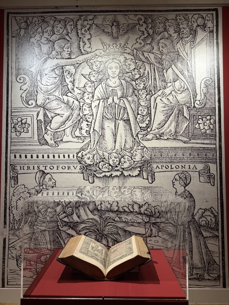 Djelo Das Deutsch Römisch Brevier (1518.) iz fonda NSK izloženo pred uvećanom preslikom ilustracije iz Brevijara na kojoj su prikazani Krsto i Apolonija Frankopan