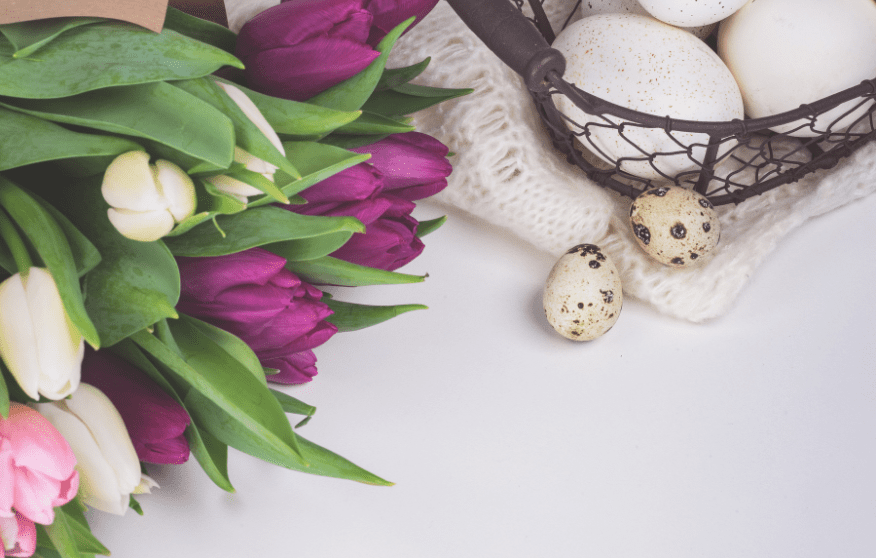 White, pink and purple tulips, eggs and other Easter decorations.