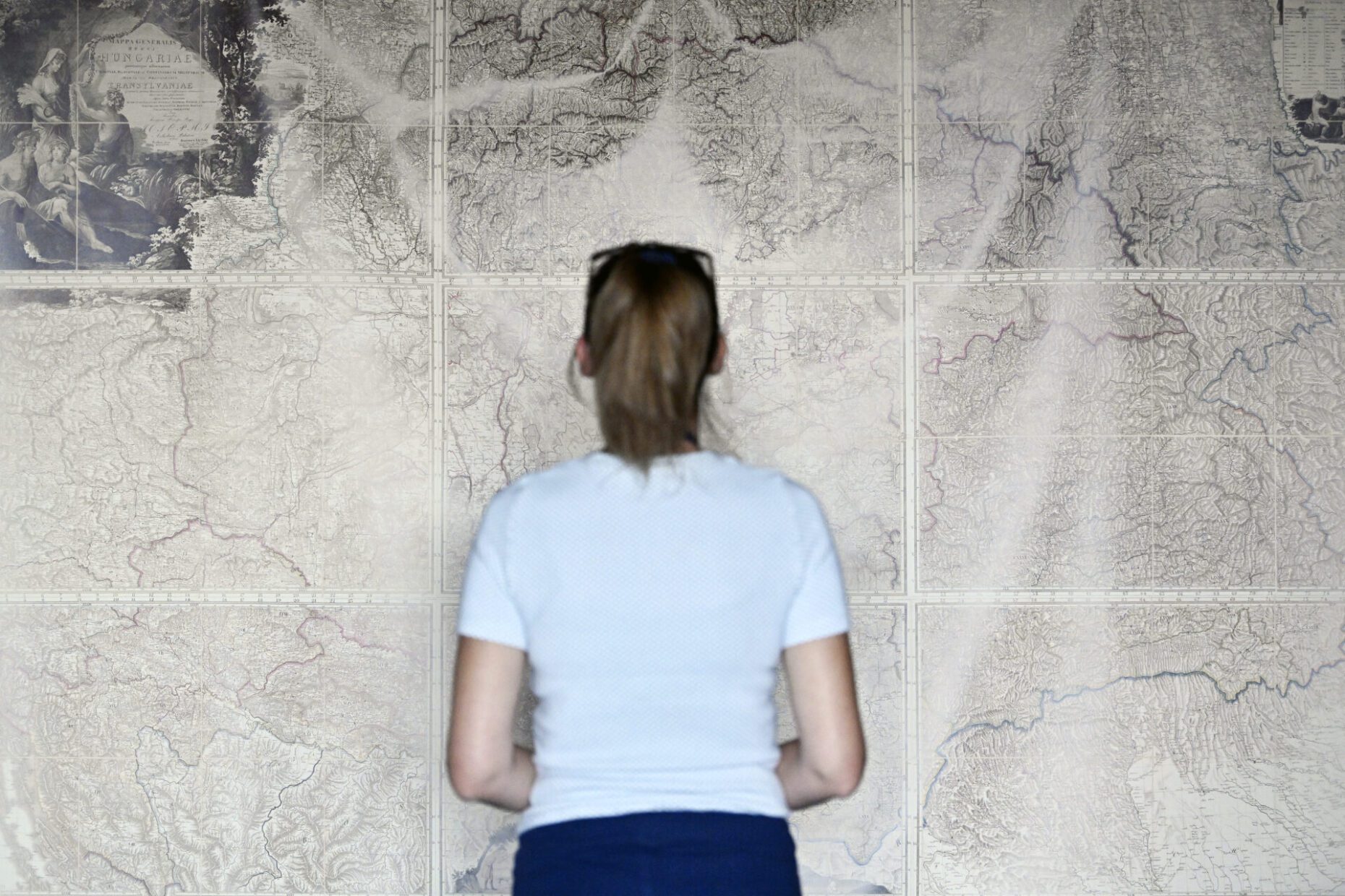 Osoba stoji ispred velike zidne karte u Zbirci zemljovida i atlasa NSK